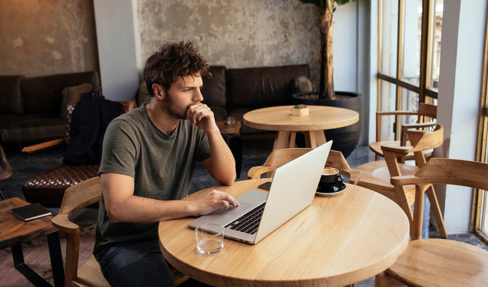 homme travaillant en mission freelance finance dans un café